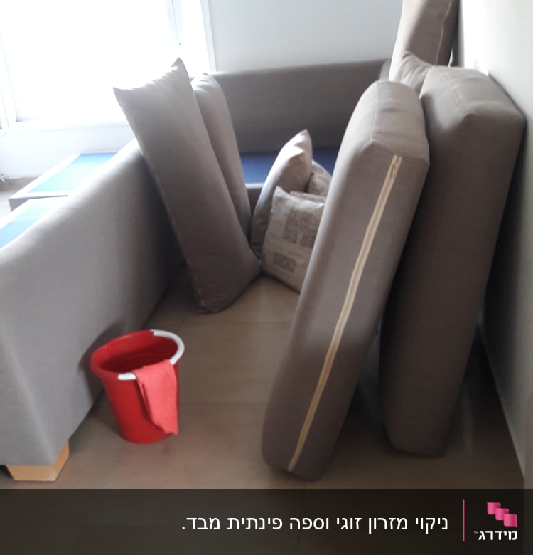 כריות ספה מונחות על הרצפה עם דלי אדום